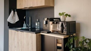 A modern kitchen with a built-in microwave, a sink, and wooden cabinets. - Lodge with a Pool (Pancé)