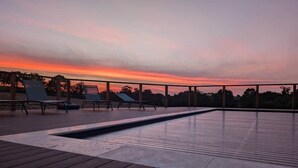 A rooftop pool with lounge chairs and a sunset view. - Lodge with a Pool (Pancé)