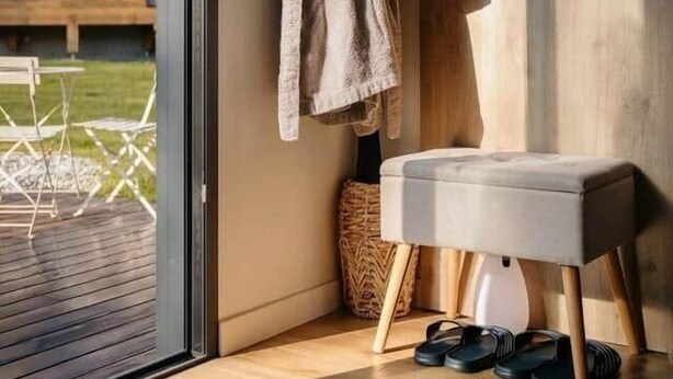 A modern bathroom with a wooden floor, a bench, and a towel rack with a robe. - Lodge with a Pool (Pancé)