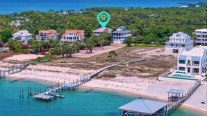 Une propriété située sur la côte, comprenant plusieurs maisons, une plage et une jetée.