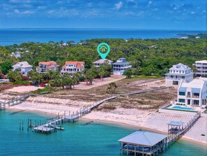 A coastal property with multiple houses, a beach, and a pier.