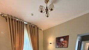 A living room with a sofa set, a rug, and a ceiling light fixture. - Pakhlavon Boutique Hotel (Khiva)