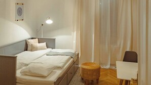 Ein Schlafzimmer mit Bett, Nachttisch, Lampe und einer Pendelleuchte.