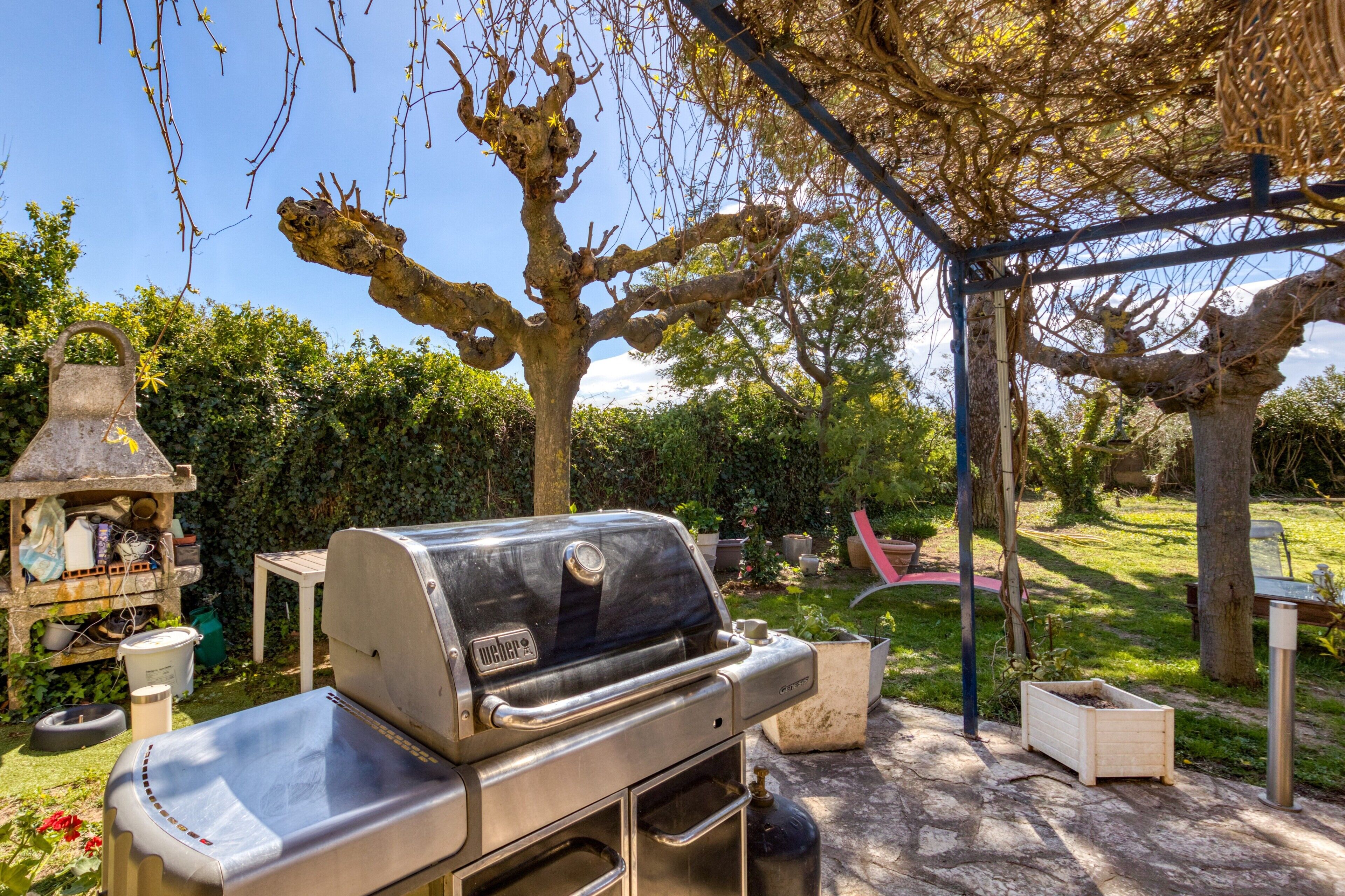 A backyard with a grill, a small table, and a garden.