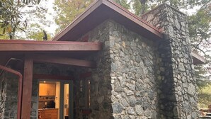 Ein Steinhaus mit Holztür und einer kleinen Veranda.