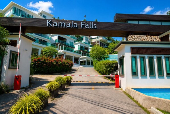 Una entrada con portón a las Cataratas Kamala, con un moderno conjunto de edificios al fondo.