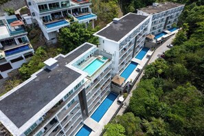 A multi-story hotel with rooftop pools and balconies.