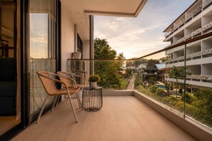 Un balcon donnant sur une piscine et les bâtiments environnants.