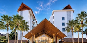 A modern hotel with a distinctive triangular entrance, white exterior walls, and a wooden roof.