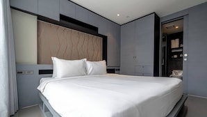 Quarto moderno com cama grande, armário embutido e toucador com espelho.