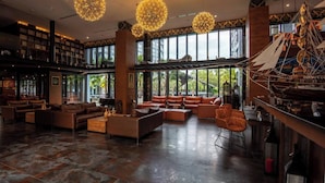 A spacious lobby with leather sofas, a coffee table, and a large ship model. - Suite Celeste 1br | Sunset rooftop|citygate kamala (Tambon Kammala)