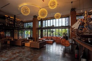 Eine geräumige Lobby mit Ledersofas, einem Couchtisch und einem großen Schiffsmodell.