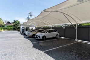 Un área de estacionamiento techada con varios coches aparcados bajo una marquesina.