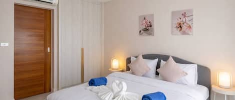 Une chambre d’hôtel avec un lit, des lampes de chevet, une armoire et des œuvres d’art murales.