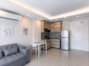 A modern apartment with a kitchenette, a dining area, and a living space.
