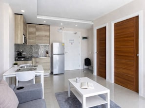 A modern apartment with a kitchenette, a dining area, and a living space.