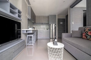 A modern living room with a flat-screen TV, a sofa, and a coffee table.