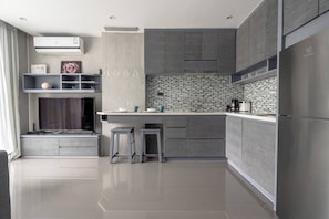 A modern kitchen with a built-in oven, a microwave, and a refrigerator.