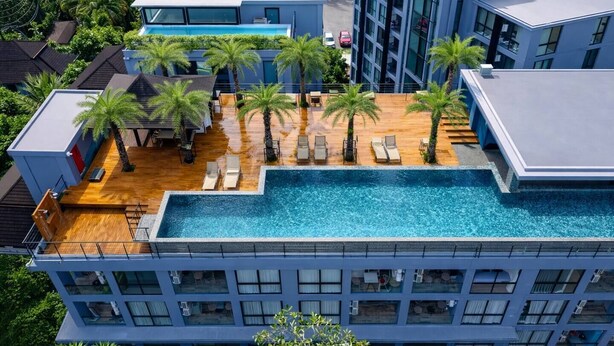 A modern hotel with a rooftop pool, palm trees, and a view of the surrounding area. - Vista 1br | discounted stay | Citygate Kamala (Tambon Kammala)