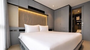 A modern bedroom with a large bed, built-in wardrobe, and a vanity with a mirror. - Vista 1br | discounted stay | Citygate Kamala (Tambon Kammala)