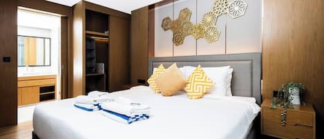 A modern hotel room with a large bed, a wooden wardrobe, and a decorative wall panel.