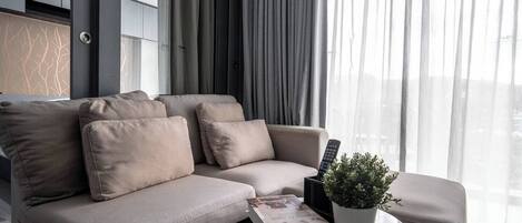 Una sala de estar moderna con un sofá, una mesa de centro y una planta en maceta.