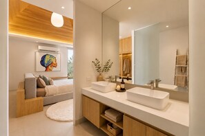 Ein modernes Badezimmer mit einem großen Spiegel, zwei Waschbecken und einer Holzkommode.
