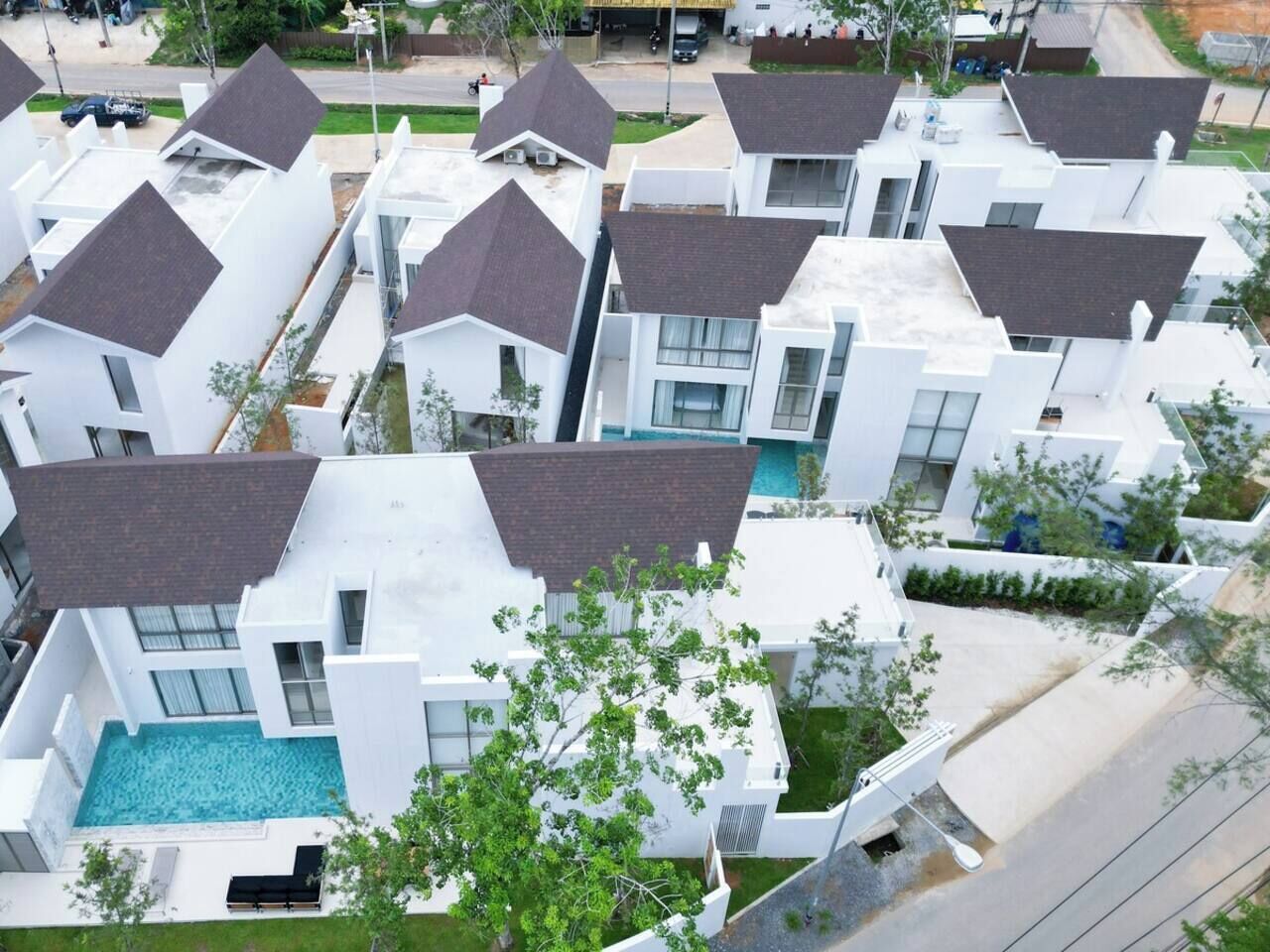 A residential area with modern houses featuring flat roofs and large windows.