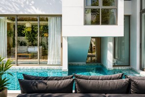 A modern house with a swimming pool, large windows, and a patio with a sofa. - Villa Valmont 4BR| Luxury Private Pool | Lux Pride (Tambon Si Sunthon)