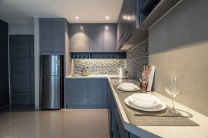 A modern kitchen with a built-in island, stainless steel appliances, and a tiled backsplash.