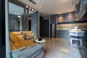 A modern kitchen with a built-in oven and a dining area with a round table and chairs.