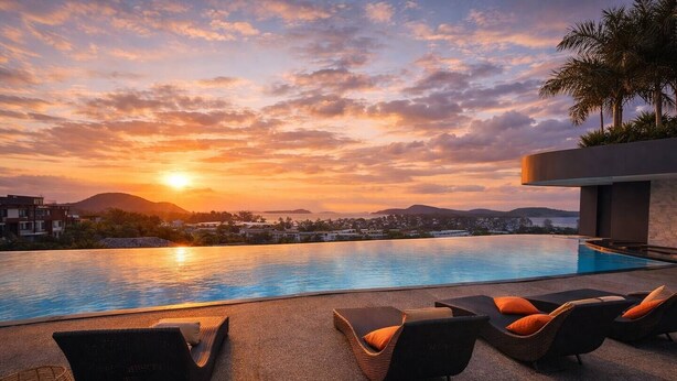 A swimming pool with lounge chairs and a sunset view.