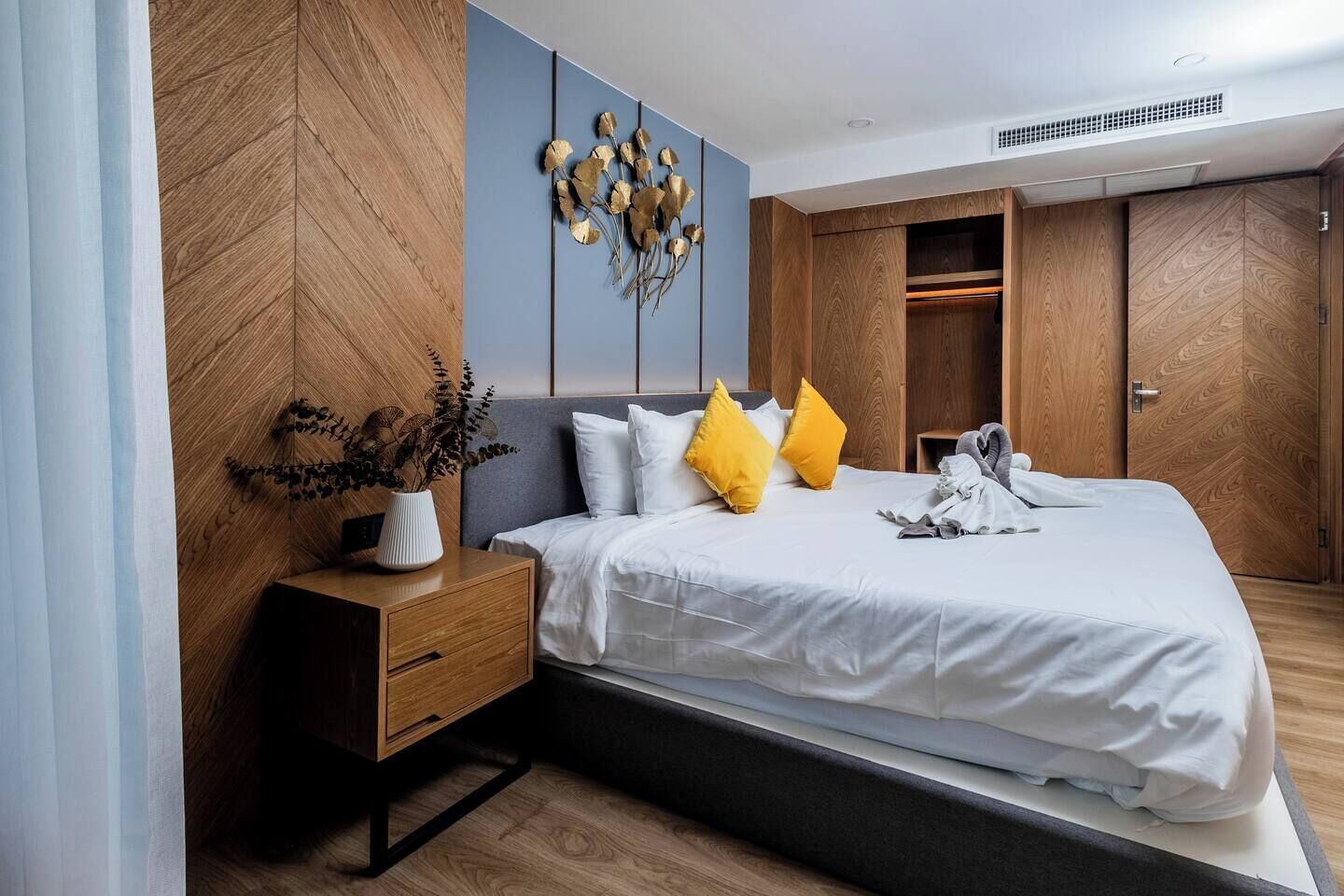 A modern bedroom with a bed, bedside table, and a wardrobe.