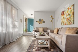 Un salon moderne avec un canapé, une table basse et un grand tableau abstrait.