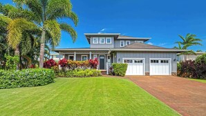 A two-story house with a front porch, a garage, and a well-maintained lawn.