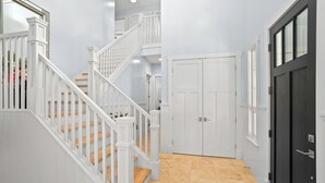 A staircase with white railings and wooden steps leading to a landing.