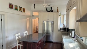 Una cocina con una isla central, refrigerador de acero inoxidable y estufa a gas.