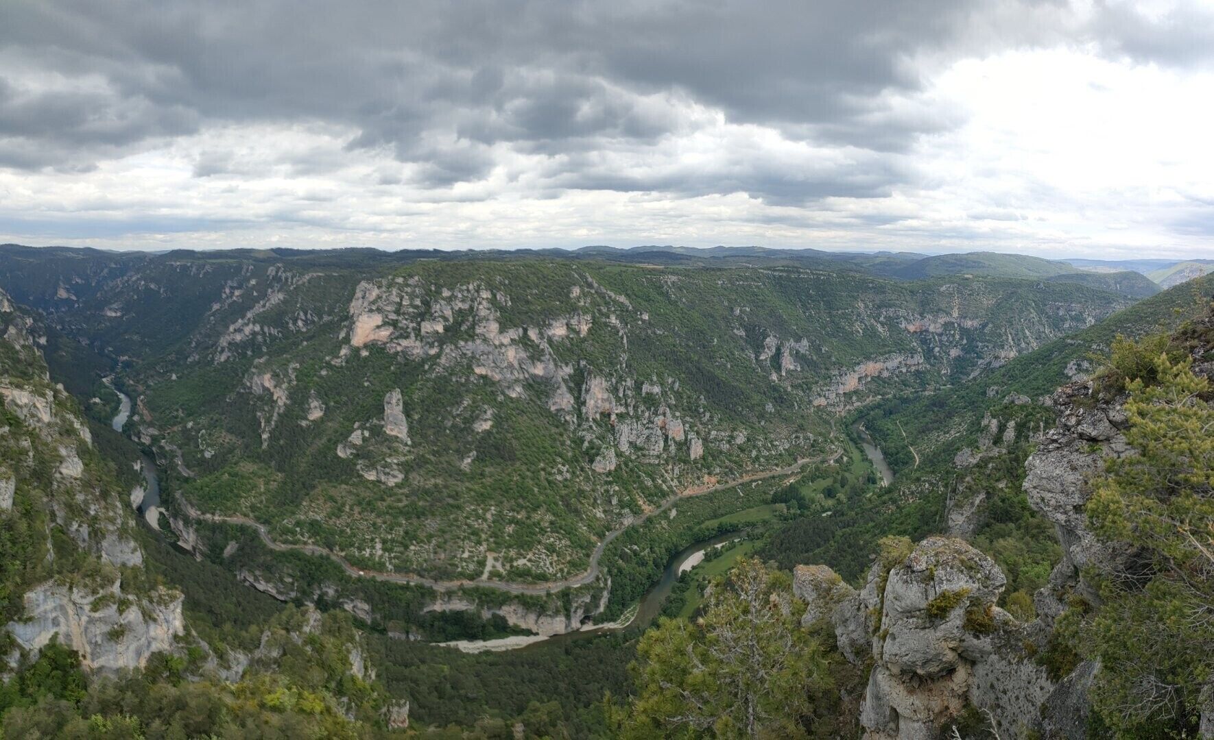 A mountainous landscape with a winding river and a road.