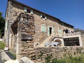 Un bâtiment en pierre sur lequel on peut lire l’inscription : « CHAMBRES D’HÔTES Le Soleil ».