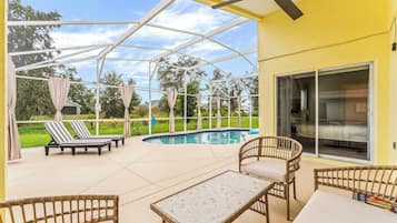 Een buitenzwembad, ligstoelen bij het zwembad