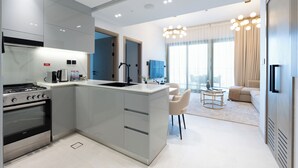 Eine moderne Küche mit Kochinsel, integriertem Backofen und Essbereich mit rundem Tisch und Stühlen.