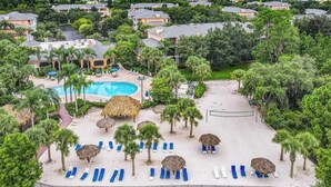 Un resort con piscina, sillas de descanso y palmeras.