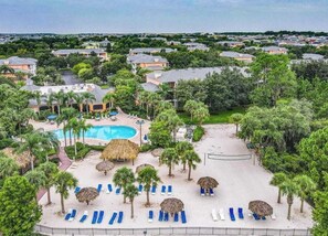 A resort with a swimming pool, lounge chairs, and palm trees. - Palm Breeze At Bahama Bay 8ppl (Davenport)