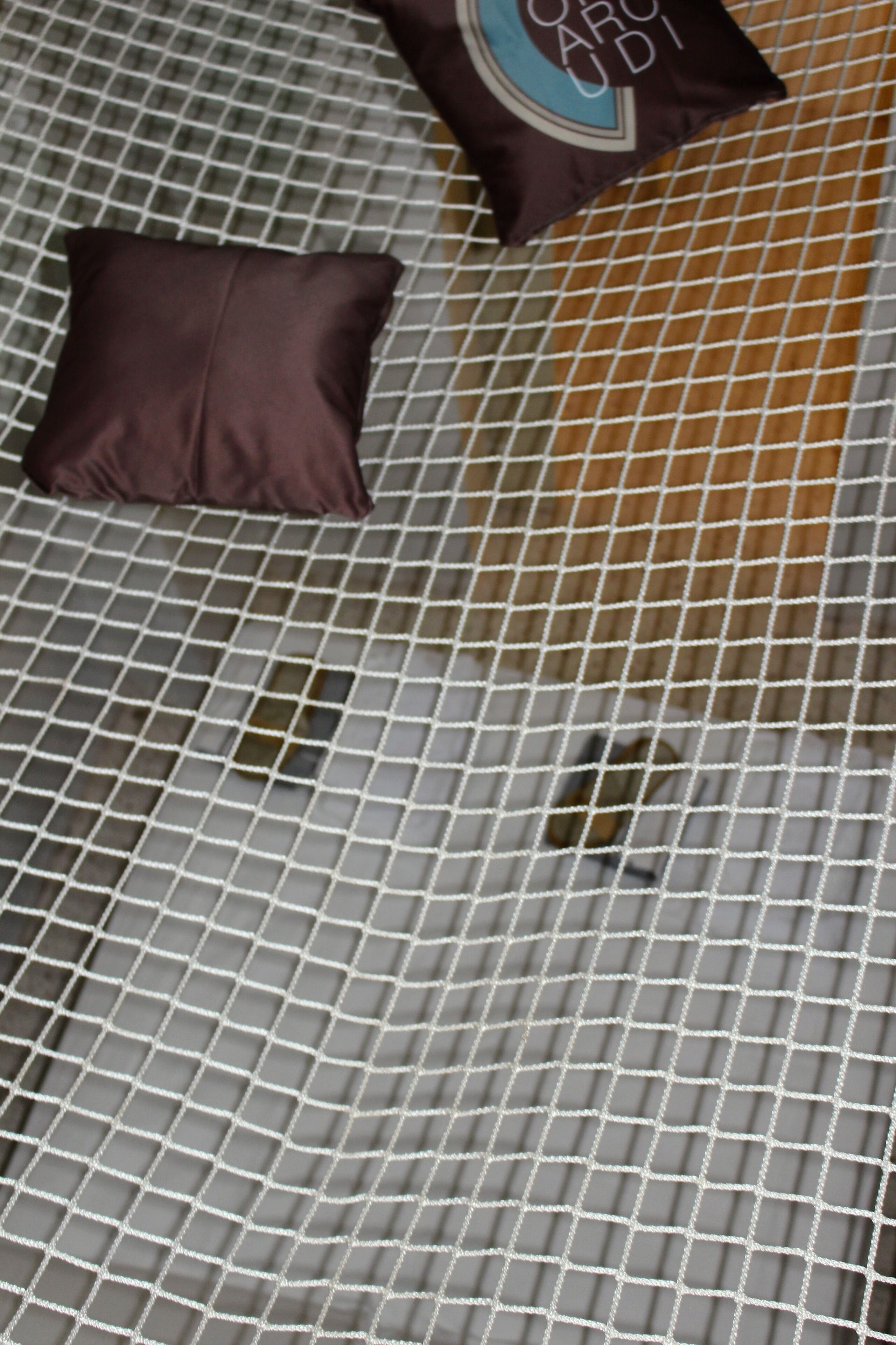 Ein Detailaufnahme eines Mesh-Betts mit einem Kopfkissen und einem Etikett.