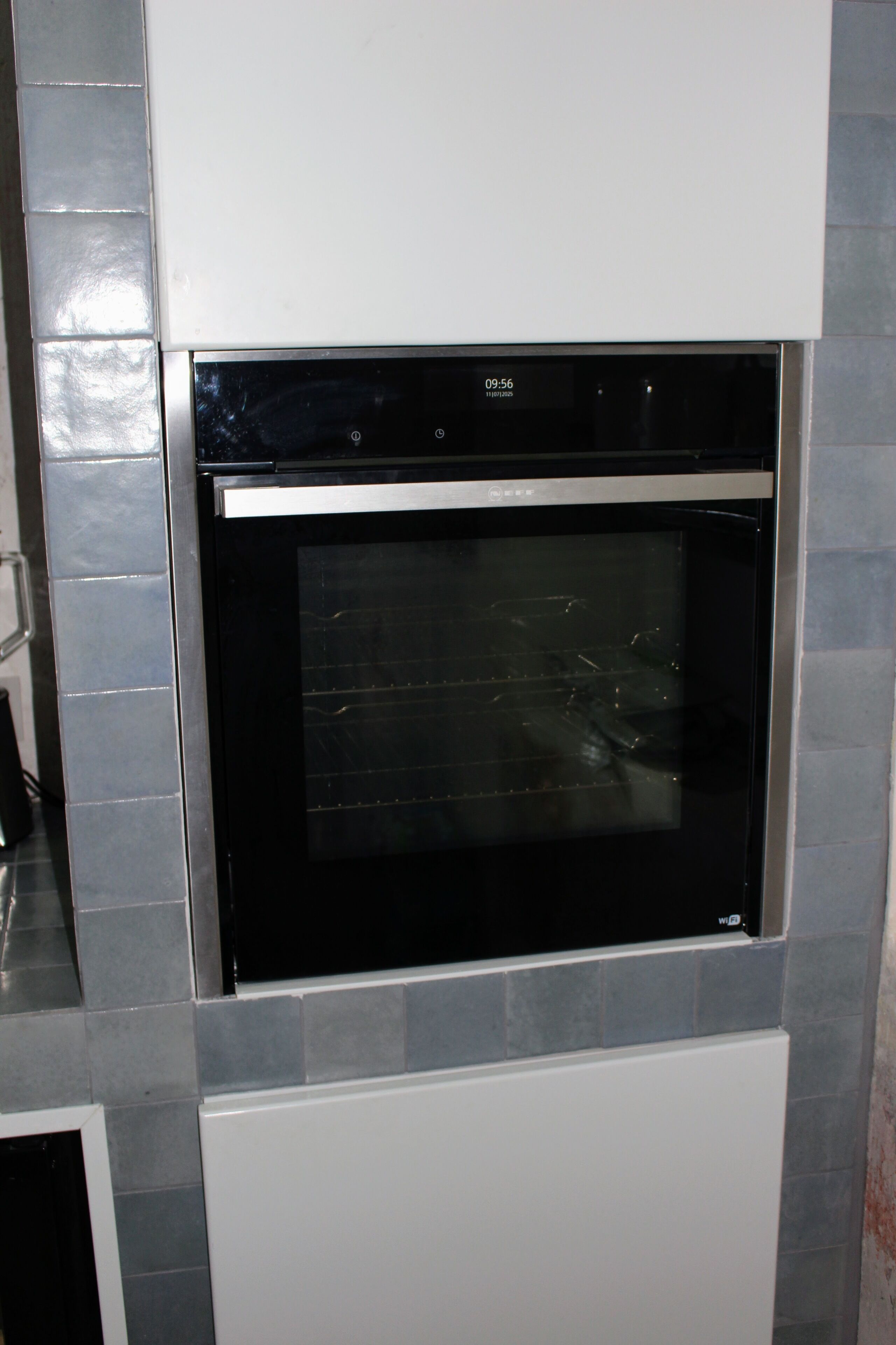 A kitchen with a built-in oven and a microwave.