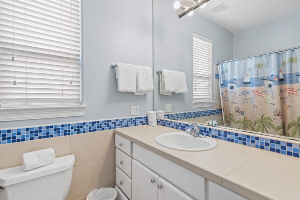 Une salle de bain avec des toilettes, un lavabo et un miroir.
