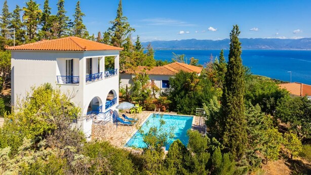 Une villa avec piscine, une terrasse et vue sur la mer.