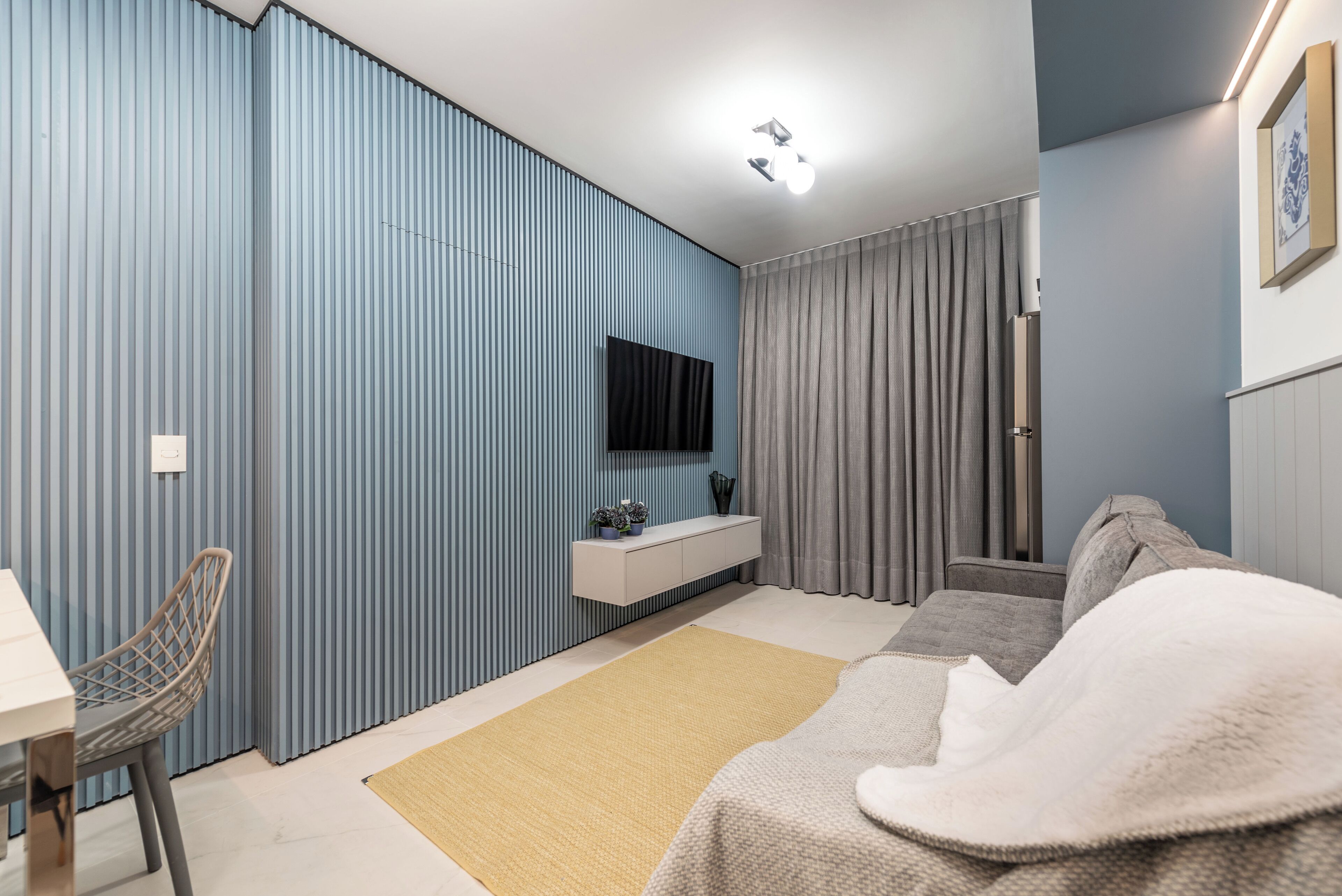 Una camera da letto moderna con un letto, una scrivania e una sedia.