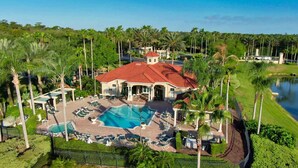 A resort with a large swimming pool, sun loungers, and a tennis court. - Magic Getaway at Emerald Island (Kissimmee)