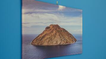 Ein gerahmtes Foto einer Vulkaninsel bei blauem Himmel.